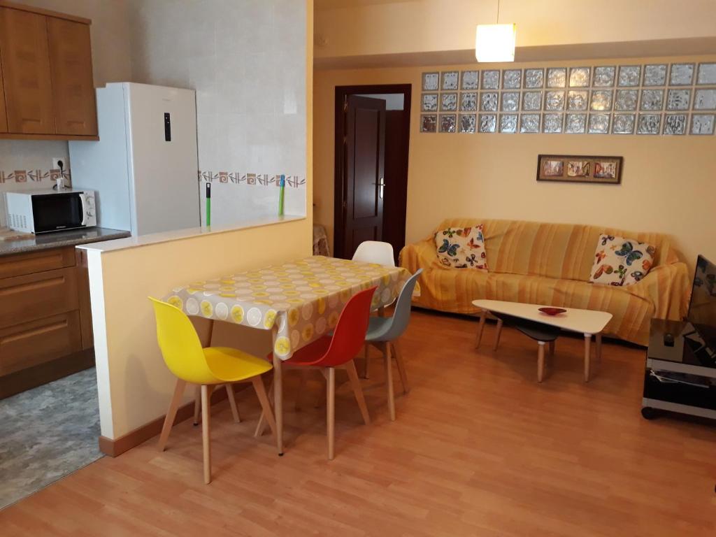 cocina y sala de estar con mesa y sillas. en Apartamento Parque de Quevedo en León