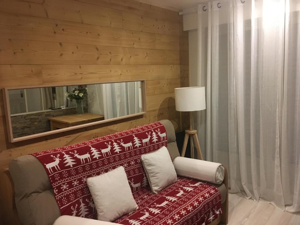 a living room with a red couch and a mirror at les Cimes d'Or Mont blanc in Les Contamines-Montjoie