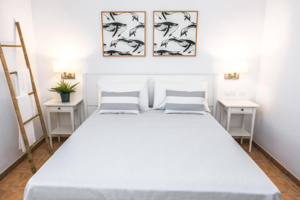 sypialnia z dużym białym łóżkiem i dwoma stolikami nocnymi w obiekcie RVHotels Sea Club Menorca w mieście Cala en Blanes