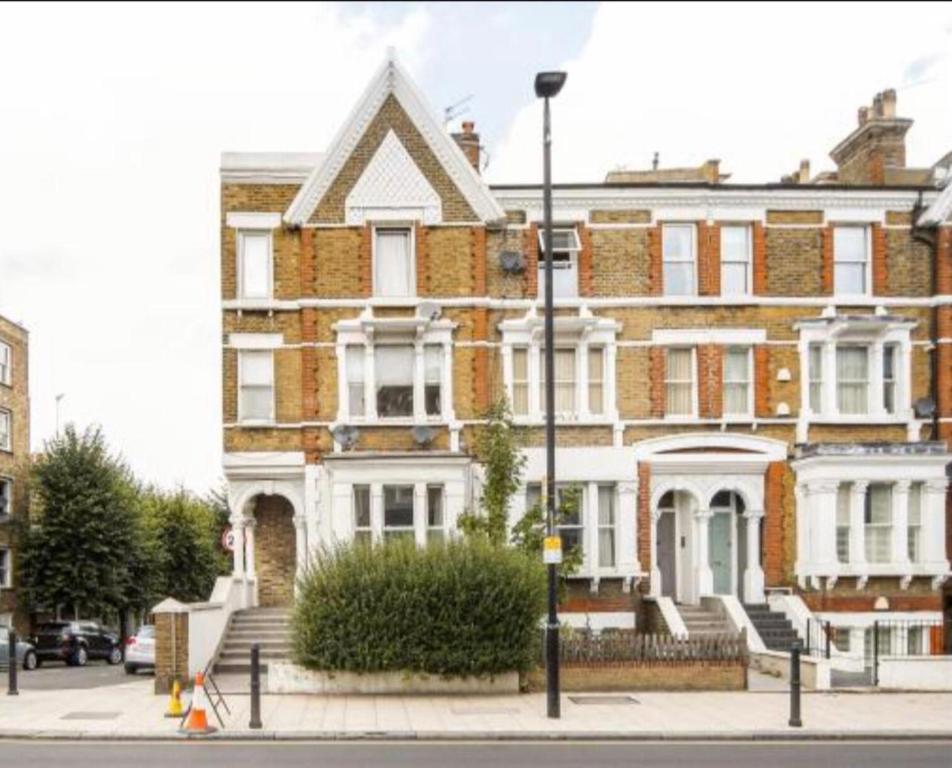 ein großes Backsteingebäude in einer Stadtstraße in der Unterkunft apartment Lavender Hill in London