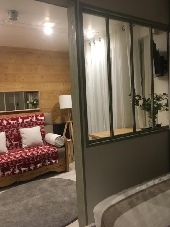 a living room with a red couch and a window at les Cimes d'Or Mont blanc in Les Contamines-Montjoie
