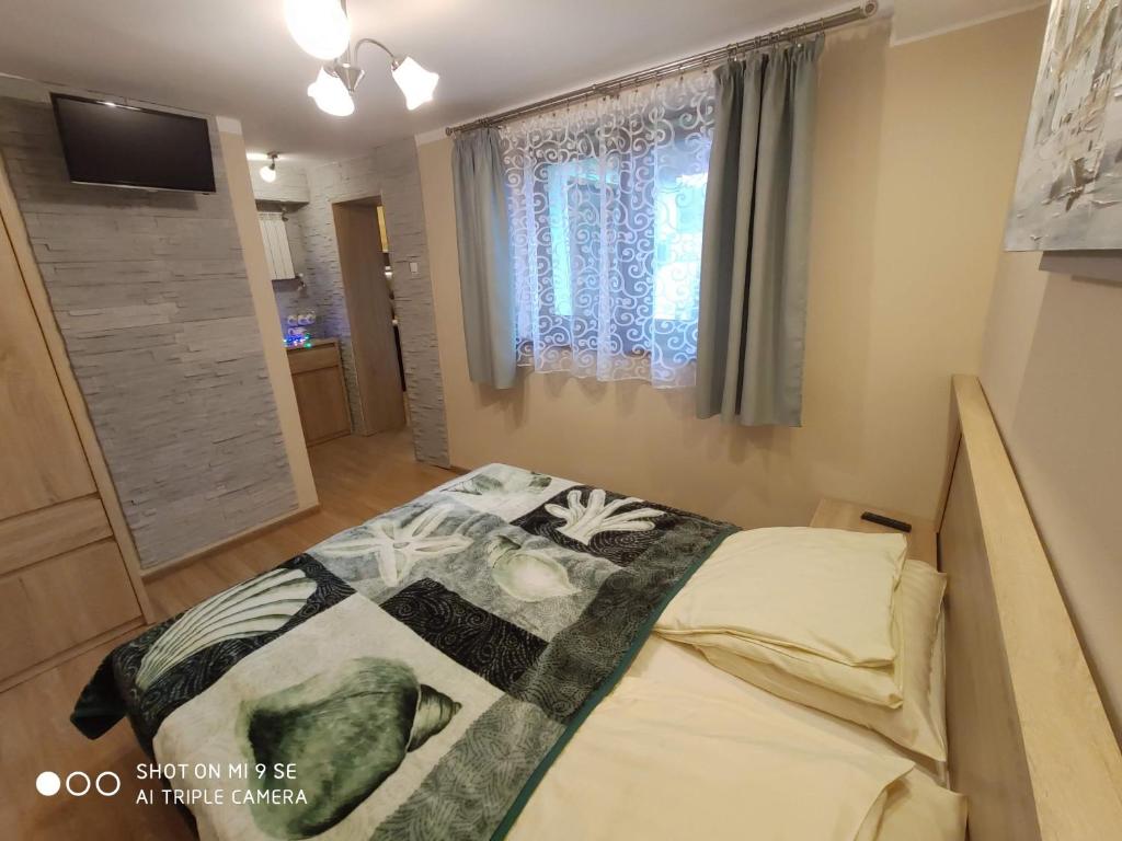 1 dormitorio con 1 cama con edredón en "MAGNOLIA" - Noclegi Pod Górą Żar, en Międzybrodzie Żywieckie