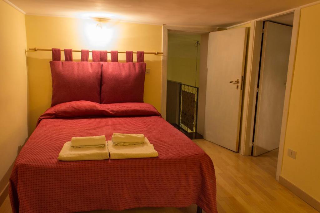 a bedroom with a red bed with two towels on it at Giganti mezzanino in Naples