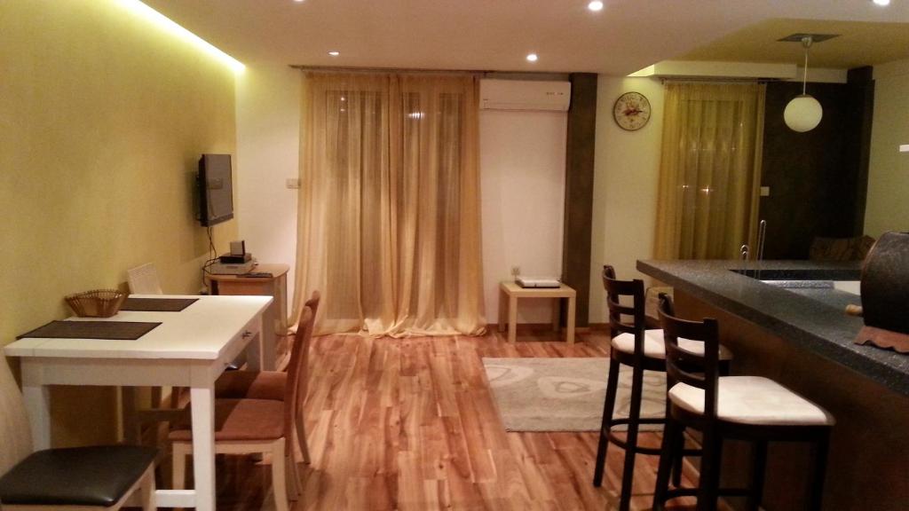 a living room with a kitchen and a table and chairs at J & P Apartments in Kotor