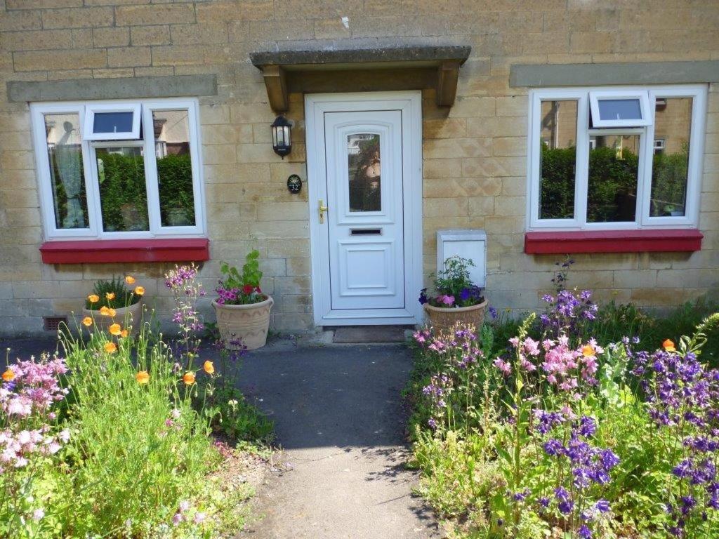 a house with a white door and some flowers at Calne Bed and Breakfast in Calne