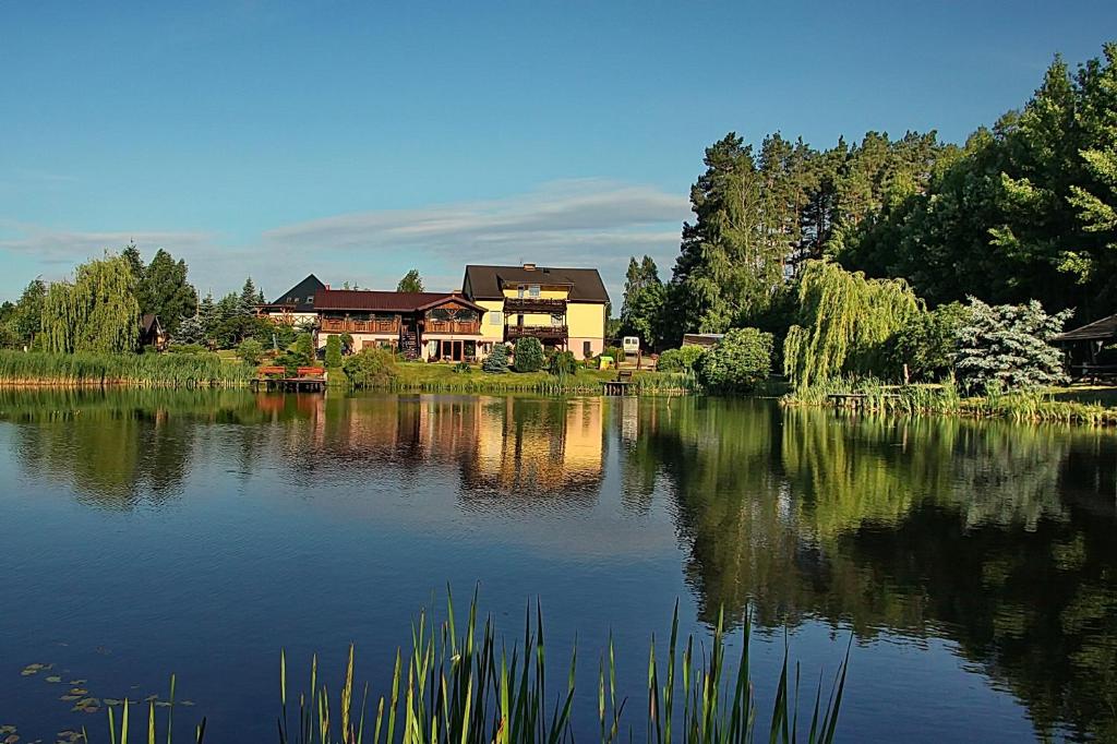 a house sitting on the edge of a lake at AGROTURYSTYKA NAD STAWEM in Lichtenstein Ostpreussen