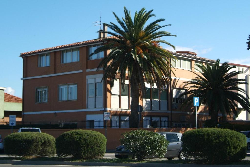 un edificio con dos palmeras delante en B&Beach Cagliari guest house, en Cagliari