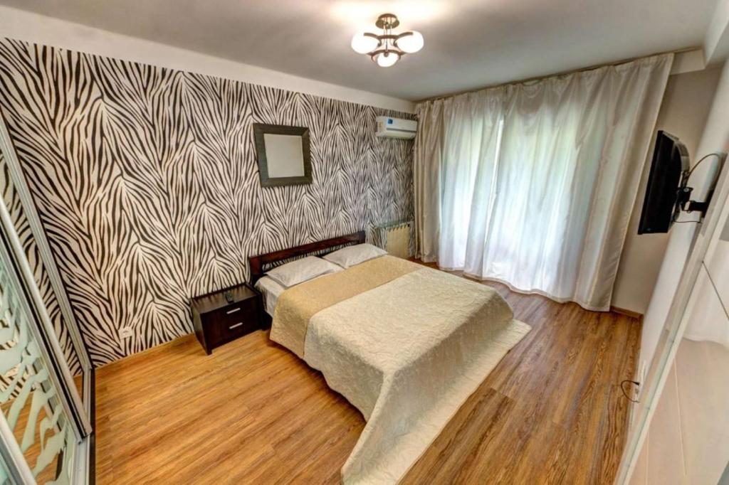 a bedroom with a bed and a patterned wall at Excellent apartment Druzhby Narodov boulevard 3a. Lybedskaya metro station in Kyiv