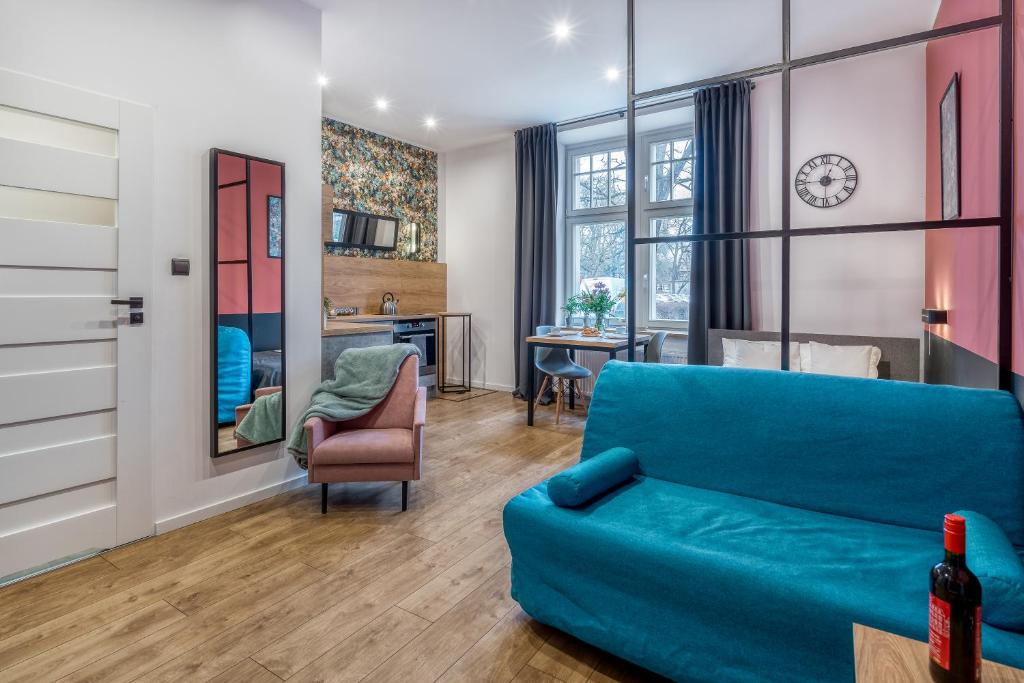 a living room with a blue couch and a table at Best4Stay Apartment - z prywatnym parkingiem in Toruń