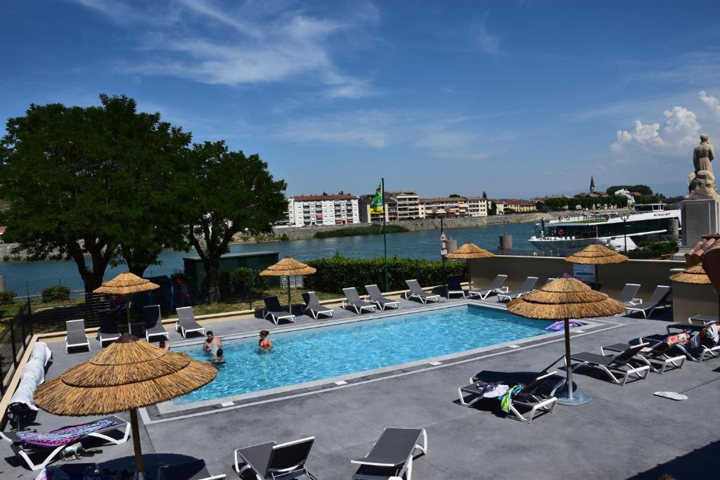 a pool with chairs and umbrellas and people swimming at Camping le Rhône in Tournon-sur-Rhône