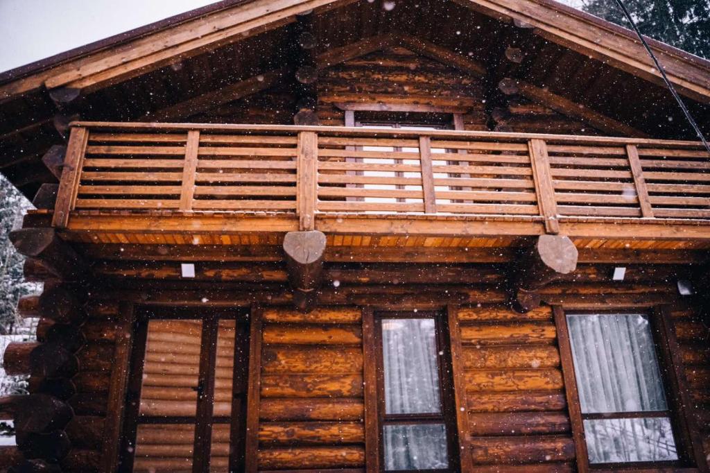 a wooden house with a balcony on top of it at Tatova Hata in Yablunytsya