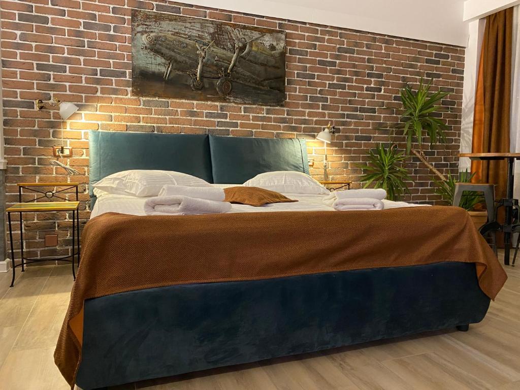 a bed in a room with a brick wall at Aviator Boutique Residence in Otopeni