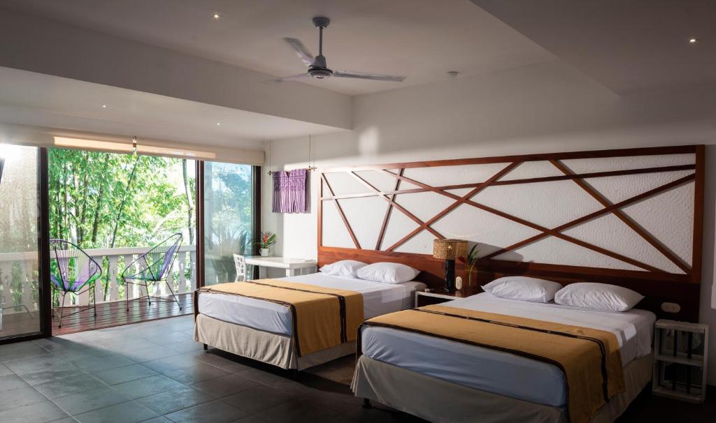 a hotel room with two beds and a balcony at Maya Internacional in Flores