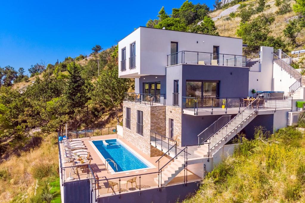 an aerial view of a house with a swimming pool at Villa Mia with private pool, Whirlpool, gym, sauna, seaviews in Lokva Rogoznica