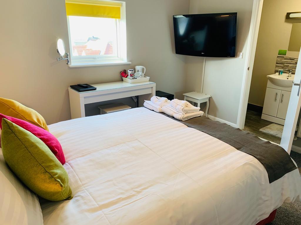 1 cama blanca grande en una habitación con TV en The Greenwich Rooms - Burger & Bird Bar & Restaurant en Peacehaven