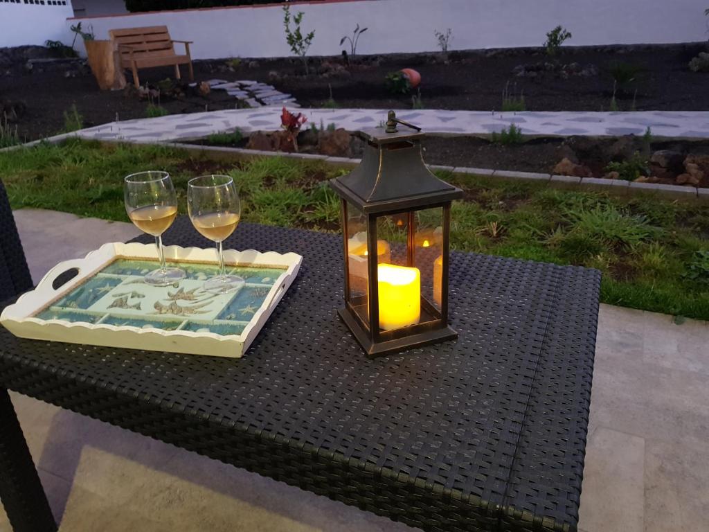 Casa Lela I في فوينكالينتي دي لا بالما: مصباح وكأسين من النبيذ على الطاولة