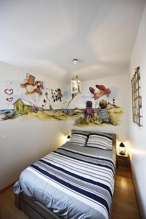 une chambre avec un lit avec un tableau sur le mur dans l'établissement Au troisième ciel - 250m de la plage - 6 pers- Berck-sur-Mer, à Berck-sur-Mer