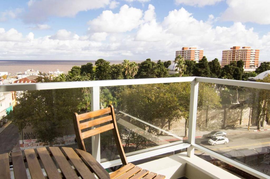 Un balcón con una silla y vistas al océano. en Brand new apt. with great views MVD, en Montevideo