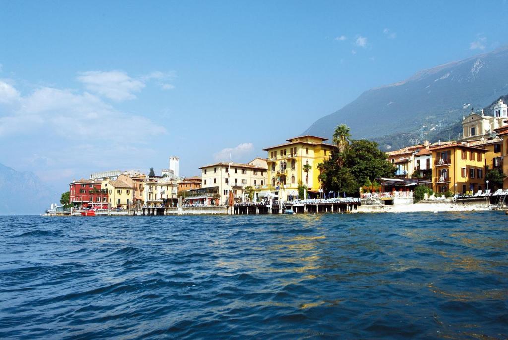 un grande bacino d’acqua con edifici e case di Hotel Malcesine a Malcesine