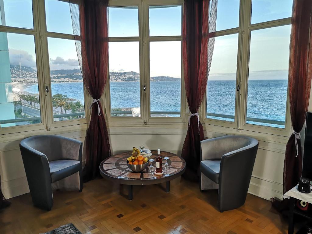 a room with two chairs and a table in front of windows at LE MIRAGE, fantastic view in Nice