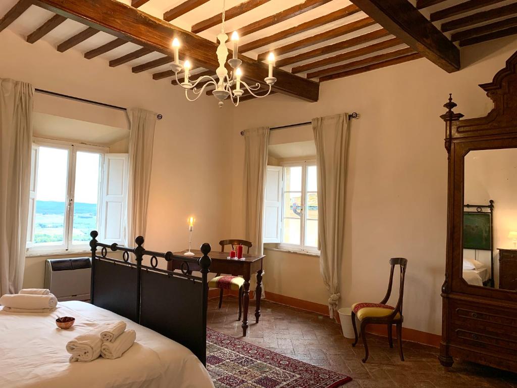 a room with a bed, table, chairs and a window at Casa Cerboneschi in Casale Marittimo