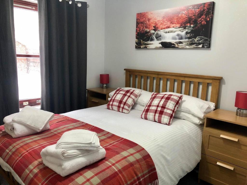 a bedroom with a bed with two towels on it at Rendezvous in Aviemore