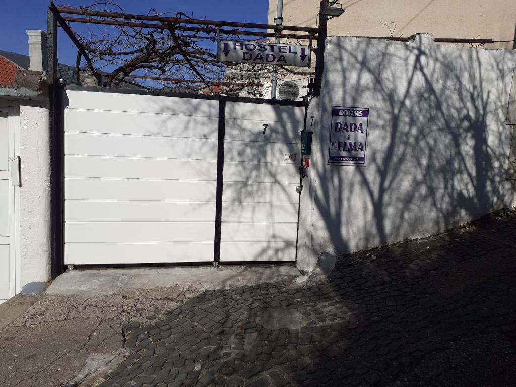 a white garage door with a sign on it at Hostel Dada in Mostar