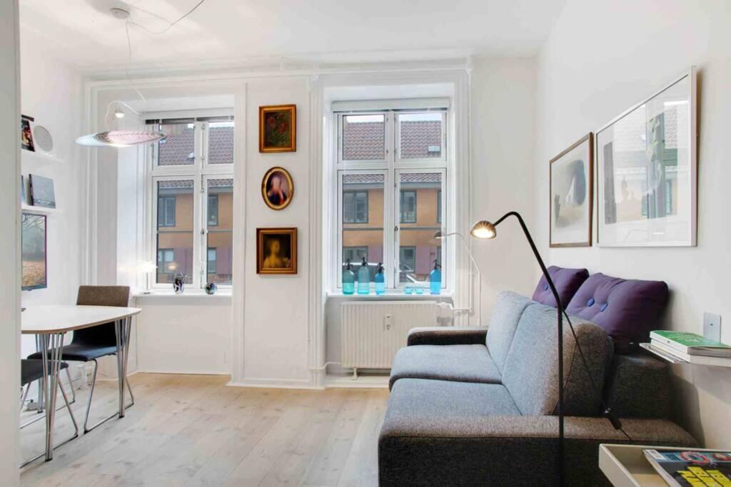 una sala de estar con un sofá y una mesa en The heart of Copenhagen-Queen's Neighbor, en Copenhague