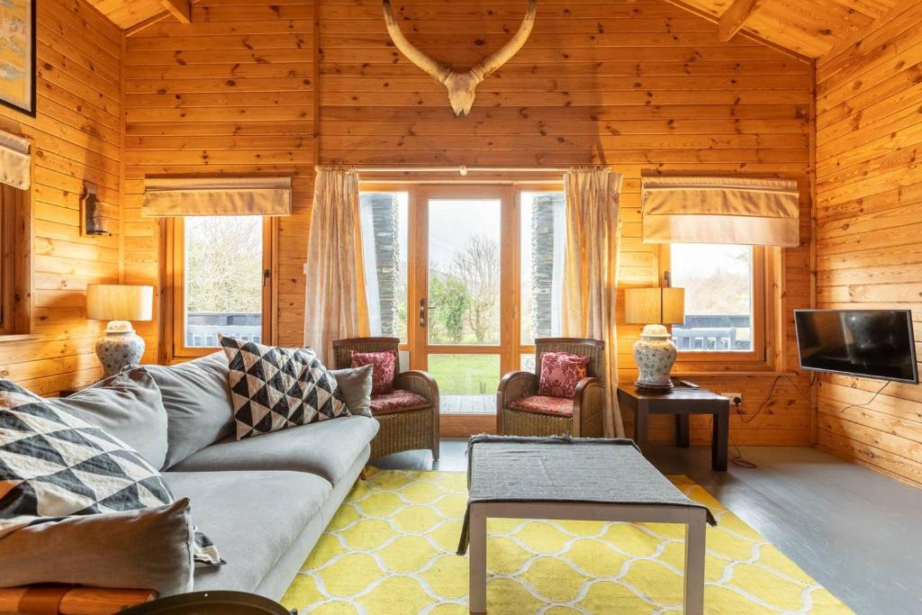 un soggiorno con divano, sedie e TV di Rock Lodge a Kenmare