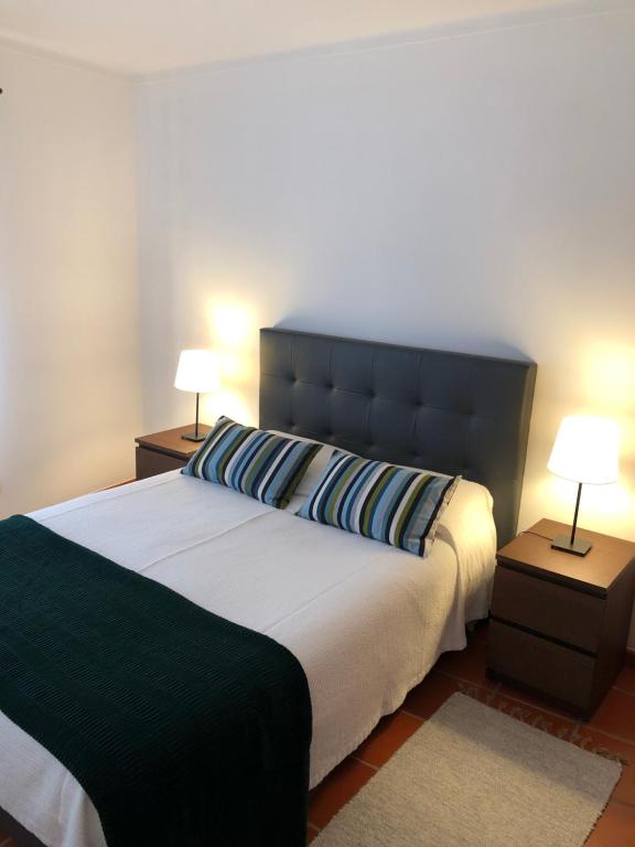 a bedroom with a large bed with two lamps at Apartamento - Casas dos Infantes in Caldas da Rainha