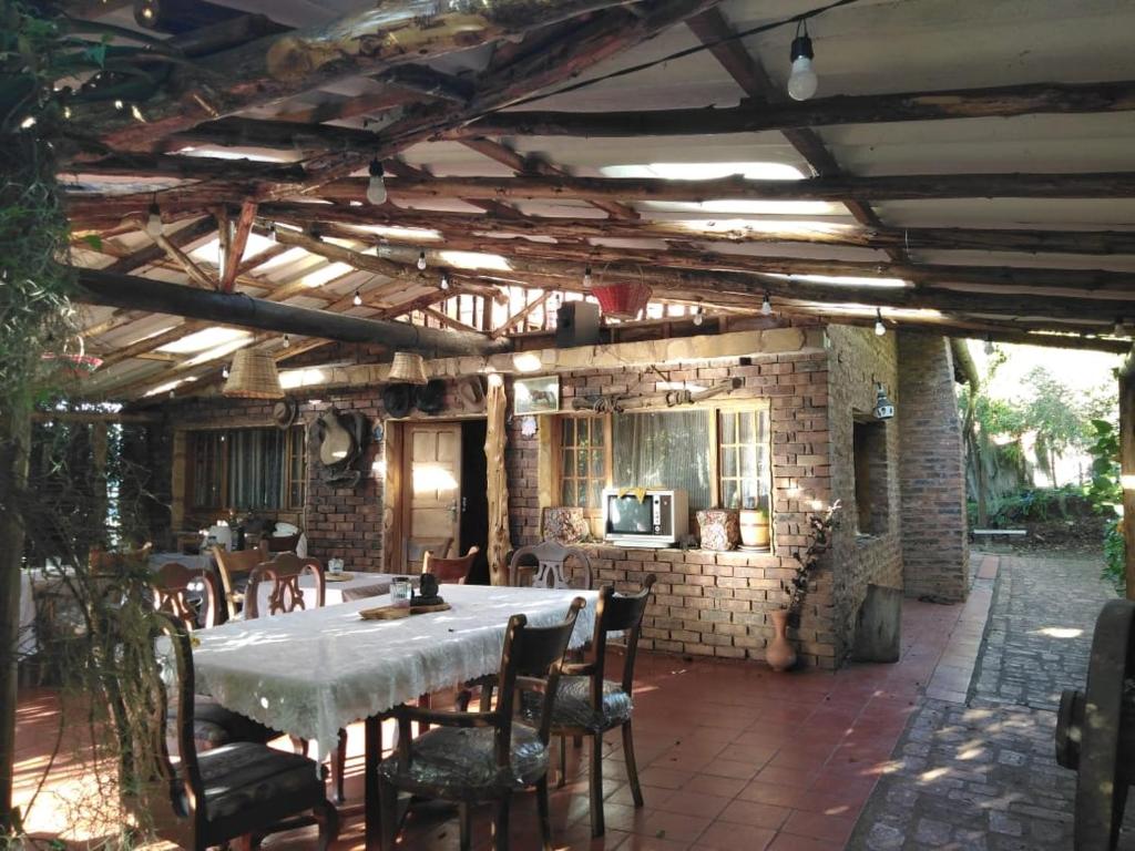 a patio with a table and chairs and a brick wall at Hotel Campestre los Duraznos in Cucunubá