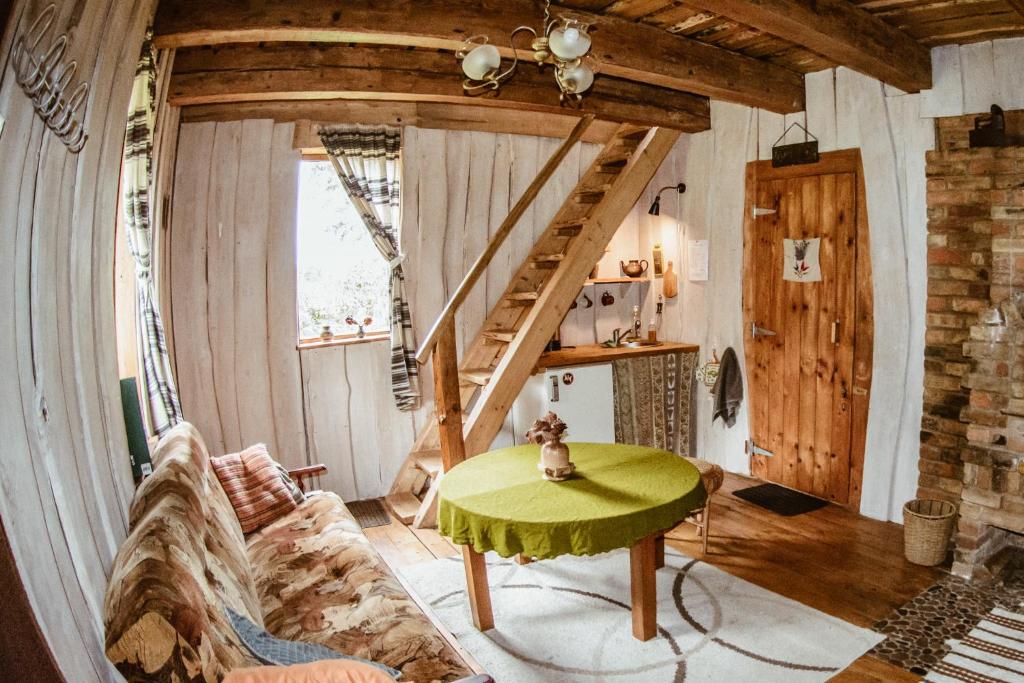 a living room with a couch and a table at Sunny Nights Homestead Rustic House in Gataučiai