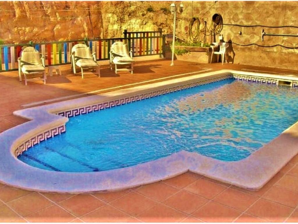 una piscina con sillas y una mesa en Belvilla by OYO Casa Crepuscle, en El Vendrell