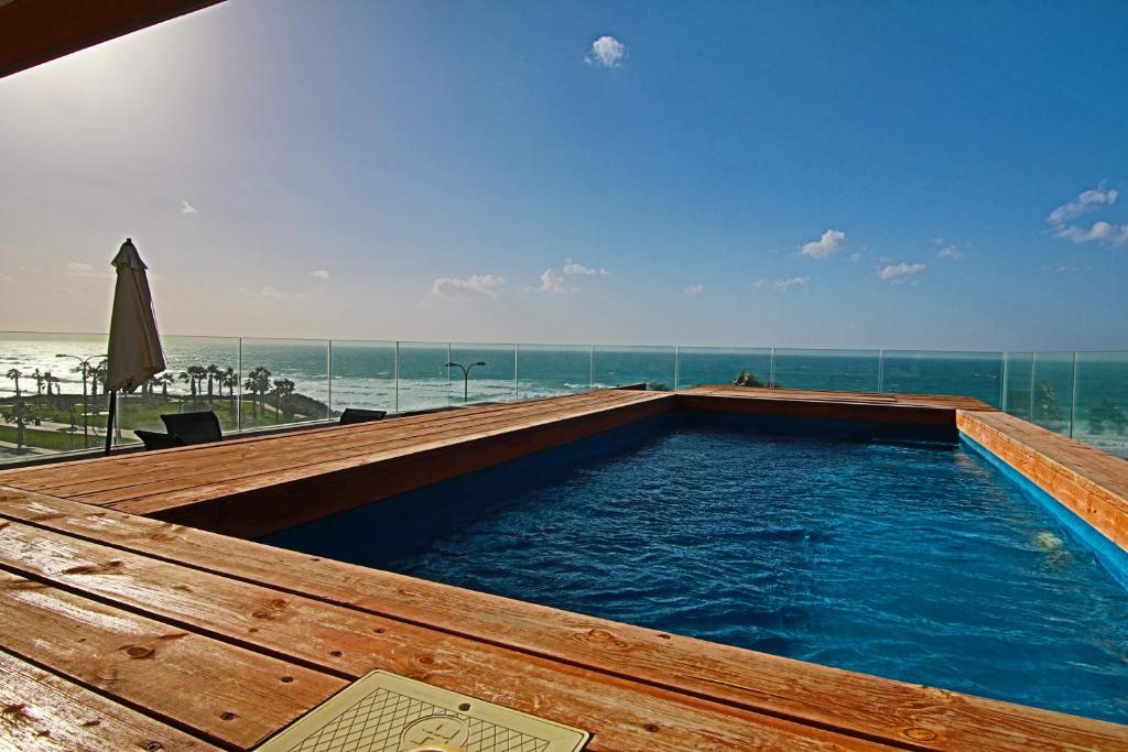 a swimming pool with a view of the beach at SeaScape Terraces Netanya in Netanya