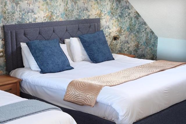 a bedroom with two beds with blue pillows at Park Hotel in Redcar