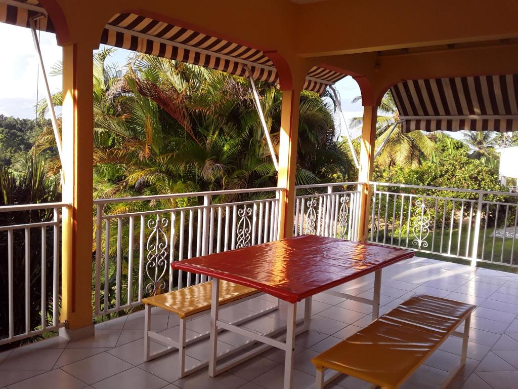 a porch with a table and chairs on a balcony at Villa Grandes pièces in Petit-Bourg