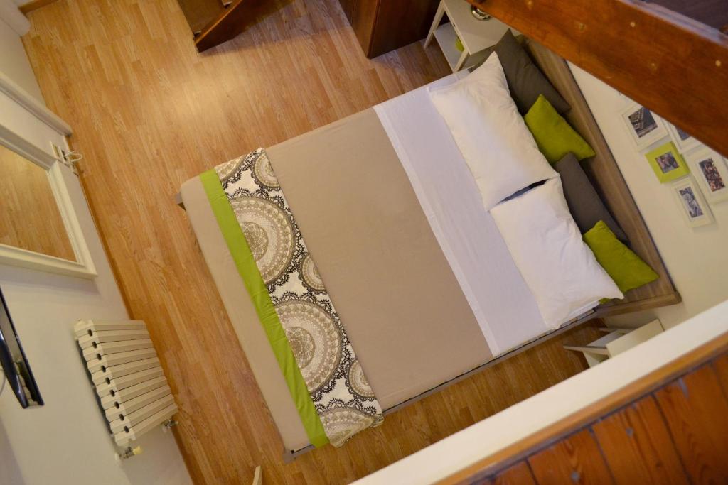 Cette petite chambre comprend un lit avec des oreillers verts et blancs. dans l'établissement Green Domus, à Florence