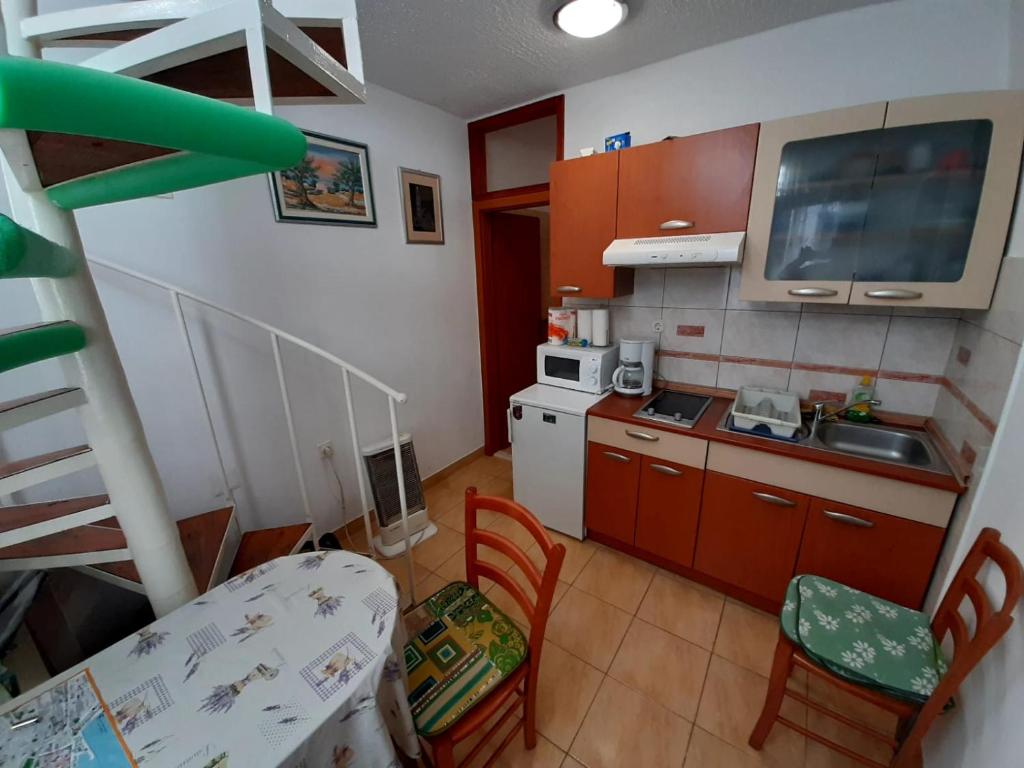 a small kitchen with a staircase leading up to a room at Rosmarinus Rubic studio in Split