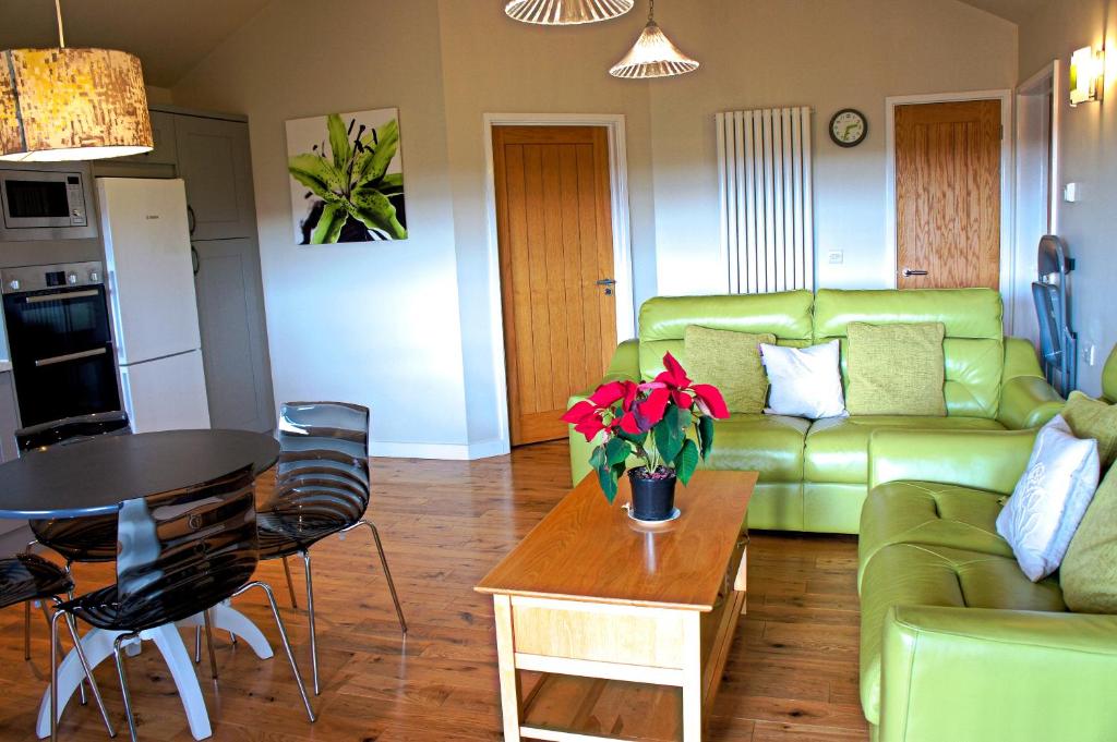 a living room with a green couch and a table at Tor Farm Lodge in Cheddar