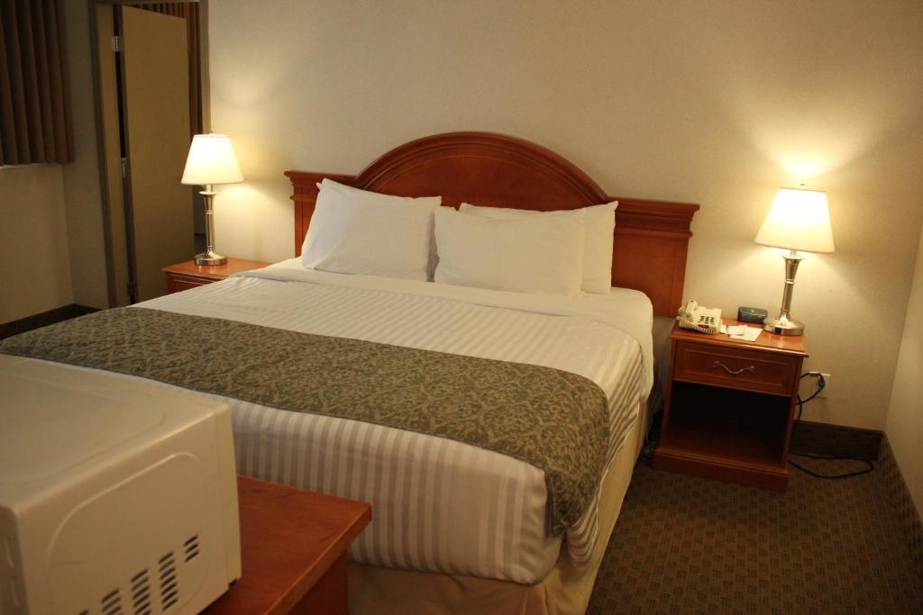 Postel nebo postele na pokoji v ubytování Ramada by Wyndham Edmonton South