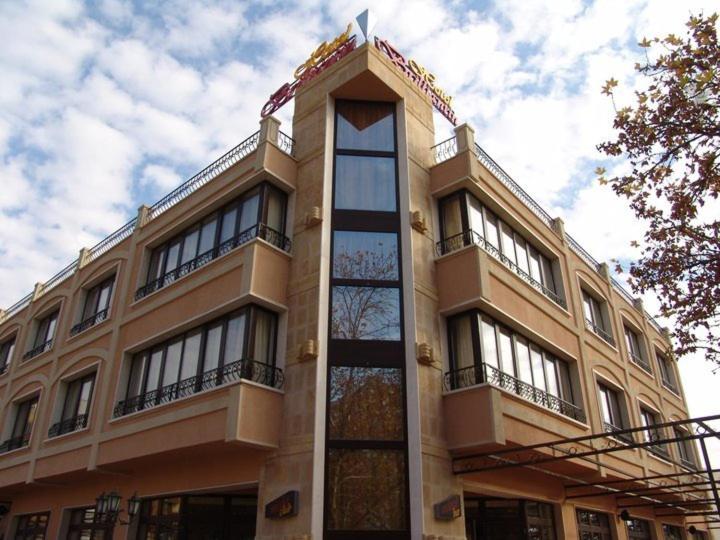 un grand bâtiment avec une horloge en haut dans l'établissement Hotel Brilliantin, à Sliven