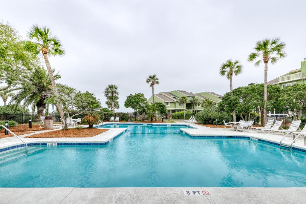 uma piscina num resort com palmeiras em Mariner's Walk 8-E em Isle of Palms