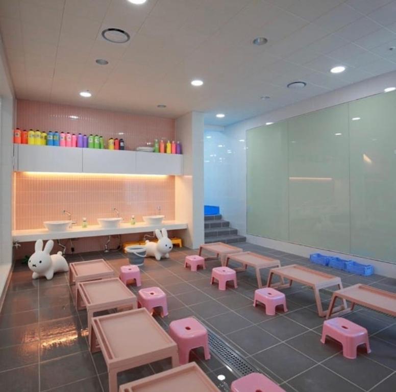 a classroom with desks and pink tables and chairs at Jeju Noblesse Hotel in Jeju