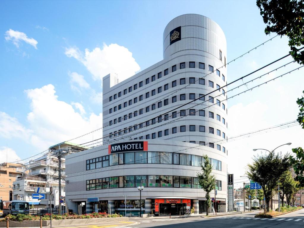 Ein hohes weißes Gebäude mit einem Schild drauf. in der Unterkunft APA Hotel Biwako Seta-Ekimae in Ōtsu