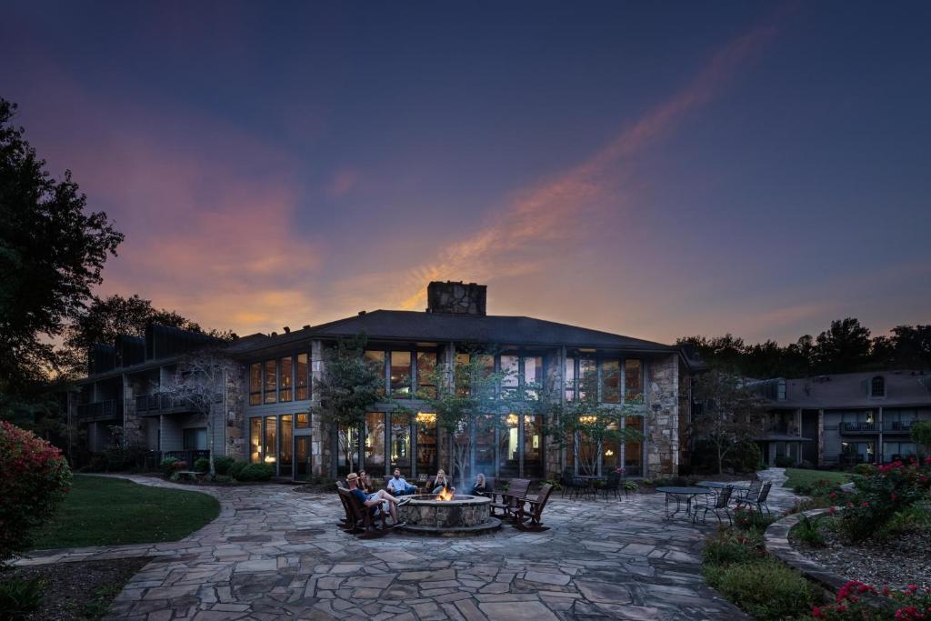 un grande edificio in pietra con persone sedute su un patio di The Ridges Resort on Lake Chatuge a Young Harris