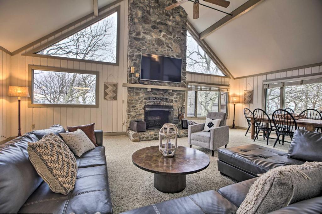 een woonkamer met leren banken en een open haard bij Mountaintop Wintergreen Resort Home with Deck, Views in Lyndhurst