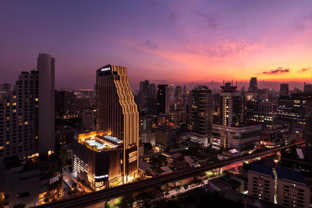 uma vista para o horizonte da cidade à noite em Carlton Hotel Bangkok Sukhumvit em Bangkok