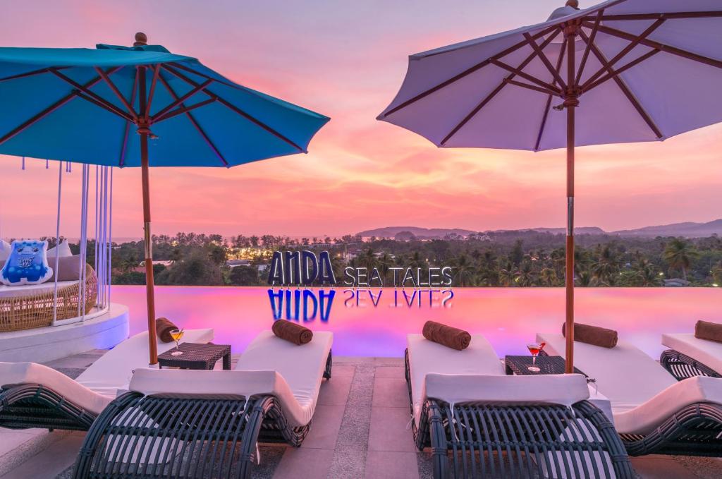 - une piscine avec des chaises longues et des parasols dans l'établissement Anda Sea Tales Resort-SHA Plus, à Ao Nang Beach