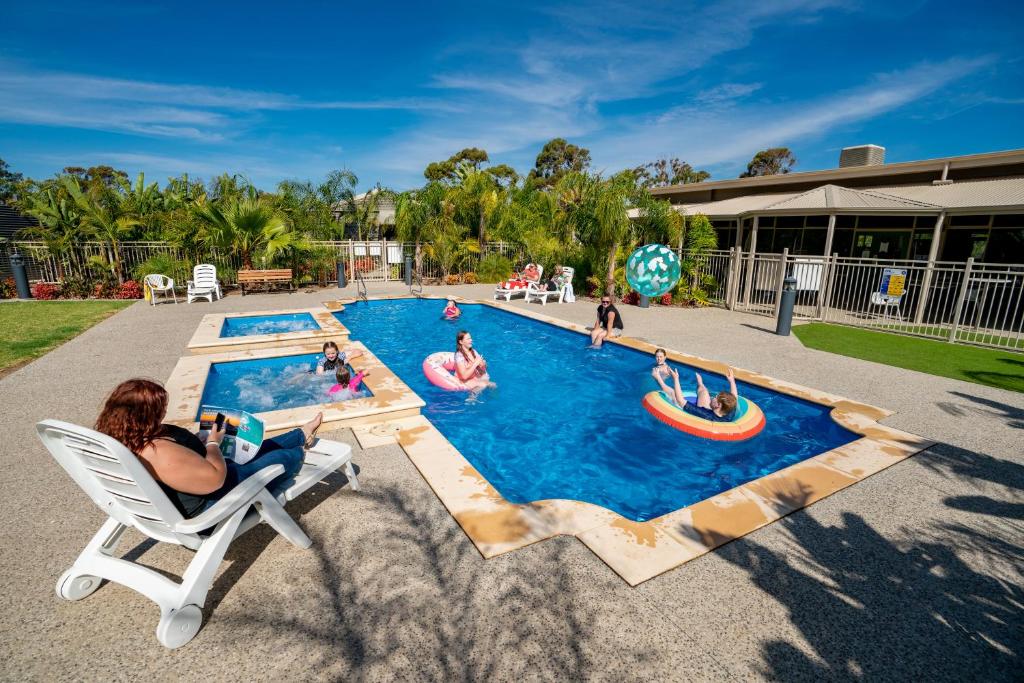 un grupo de personas jugando en una piscina en Highway 1 Holiday & Lifestyle Park en Bolivar