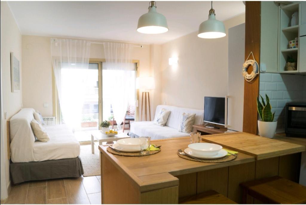 een woonkamer met een tafel en een bank bij Michelangelo, Cosy apartment in the heart of Salou in Salou